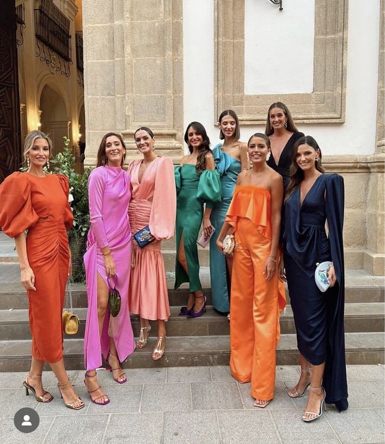 a mismatching bridal party look with orange, pink, black, navy, green and blue maxi and midi bridesmaid dresses