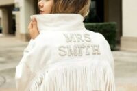 a white denim jacket with embellished letters and long fringe is a perfect addition to a boho bridal look