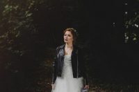 a woodland bride in a princess-style wedding dress and a black leather jacket looks fabulous and very stylish