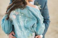 an oversized bleached denim jacket with calligraphy and pastel floral patterns handpainted is amazing
