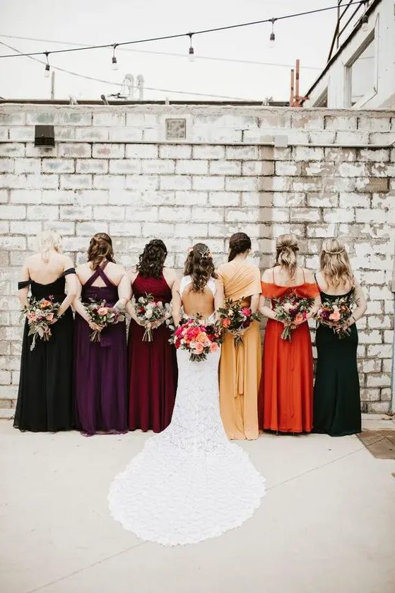 beautiful mismatching bridesmaid dresses in burgundy, deep purple, orange, marigold, black are gorgeous for the fall