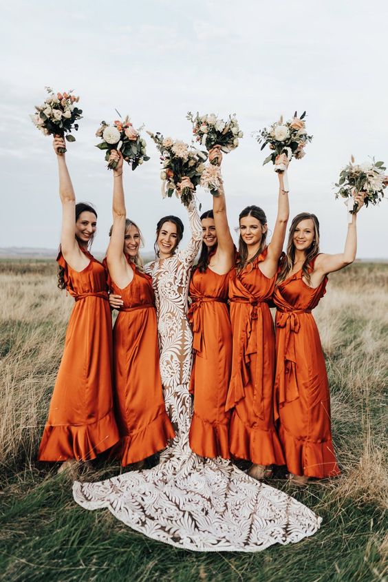 beautiful orange satin midi wrap bridesmaid dresses with ruffle necklines are a cool idea for a boho wedding