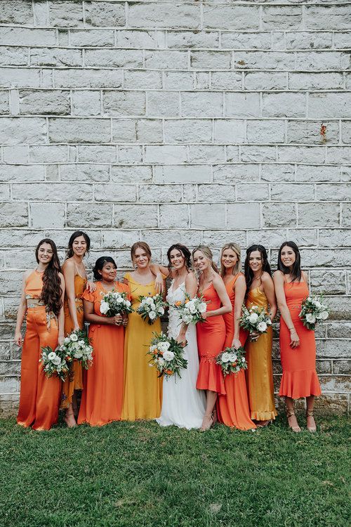 gorgeous mismatching yellow and orange midi and maxi bridesmaid dresses plus shiny shoes for a colorful summer wedding