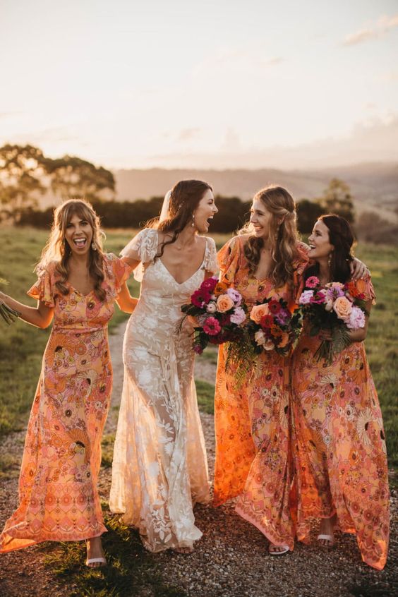Matching orange floral semi fitting bridesmaid dresses with ruffle sleeves for a cheerful summer wedding