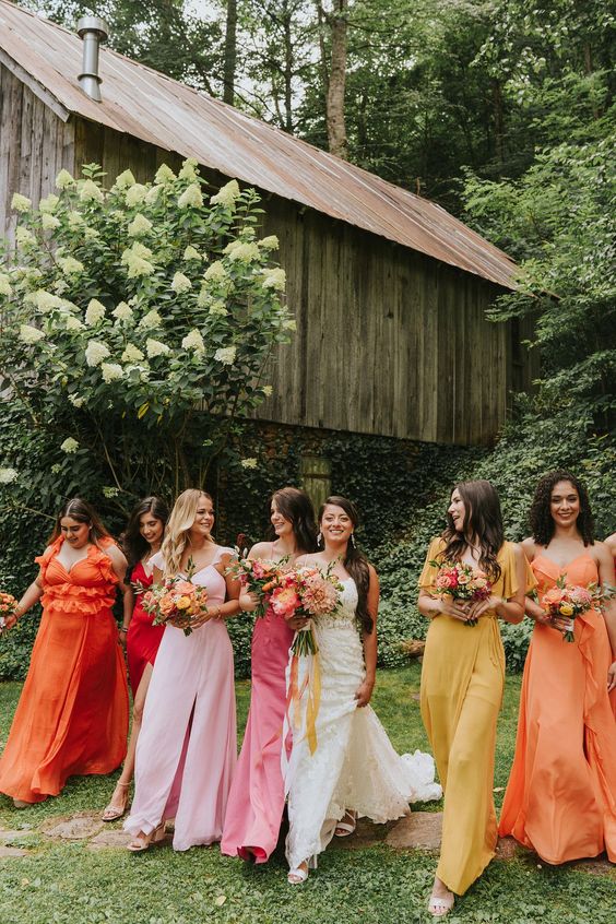 mismatched yellow, orange, pink maxi bridesmaid dresses to compose a bold mix and match bridal party look