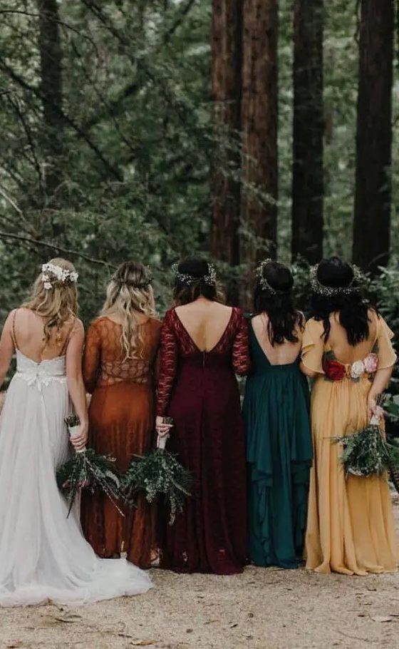 mismatching bold-colored maxi bridesmaid dresses in yellow, dark green, burgundy and orange, of plain fabric and lace for a fall wedding