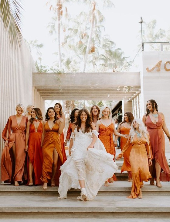mismatching bridesmaid dresses in all shades of orange are a very trendy and edgy idea