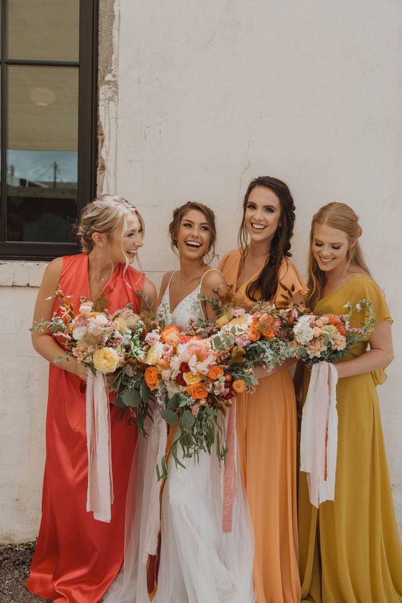 mismatching mustard, yellow and orange maxi bridesmaid dresses are a great idea for a summer wedding