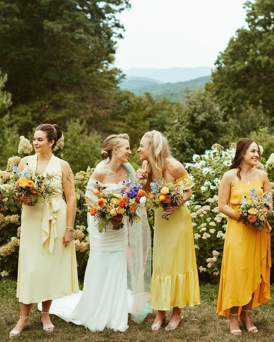 mismatching pale, bright and bold yellow midi bridesmaid dresses for a spring or summer wedding