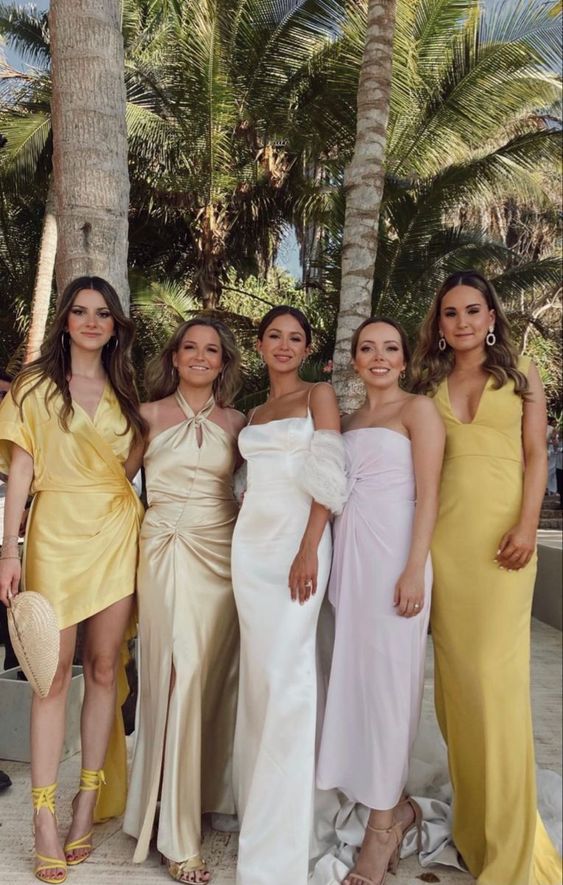 mismatching yellow and pale pink bridesmaid dresses for a super glam tropical wedding