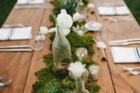 03 moss table runner decorated with white flowers, bottle vases and candles