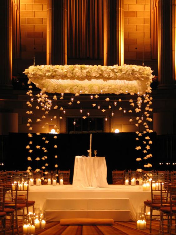 gorgeous wedding chuppah decorated with white blooms and candles