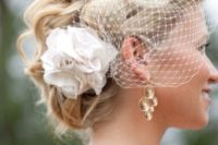 06 braided updo with a birdcage veil and a fabric flower