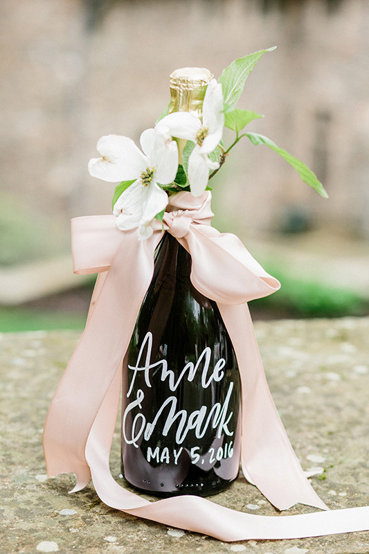 Wine bottles as favors decorated with dusty pink ribbon