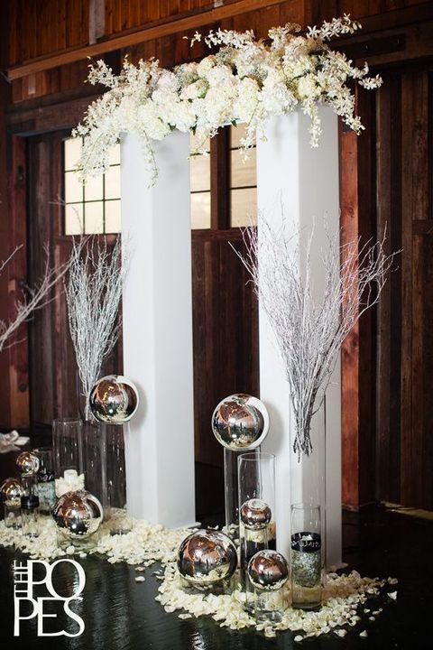modern indoor arch with white flowers and metal spheres