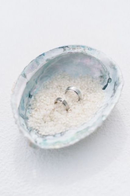 a large shell filled with sea salt as a ring box
