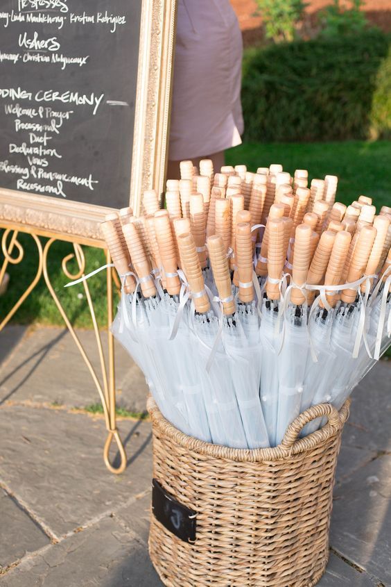 basket of clear umbrellas for wedding guests