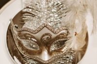 13 sparkling masks with feathers placed at each table