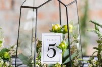 16 black geo terrarium with fresh greenery and table numbers inside