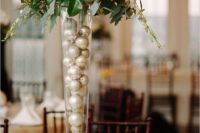 22 tall glass vases filled with ornaments and topped with flowers