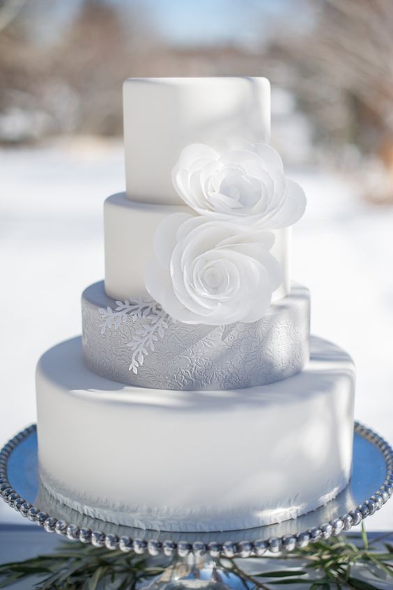 elegant pure white wedding cake with white flowers and a textural grey layer