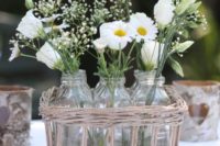 26 put bottles with flowers into a basket to get a rustic centerpiece