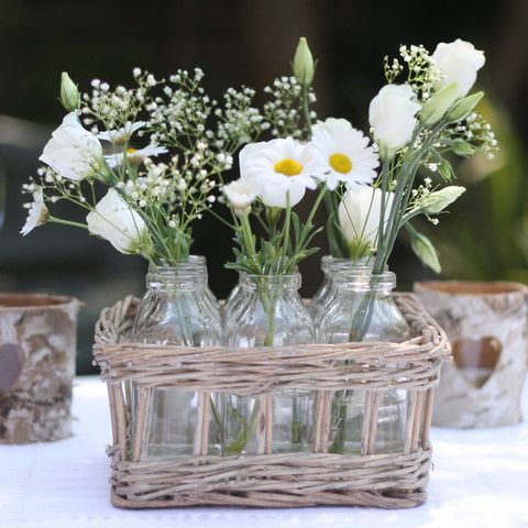 put bottles with flowers into a basket to get a rustic centerpiece