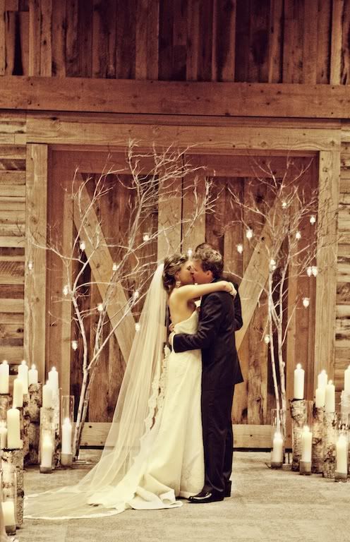 branches decorated with candles and birch log cnadle holders for a rustic big day