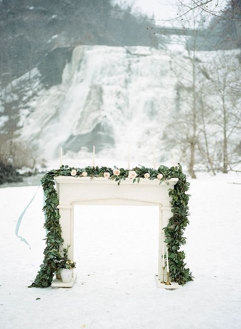 outdoor winter altar decorated with a eucalyptus garland and blush blooms
