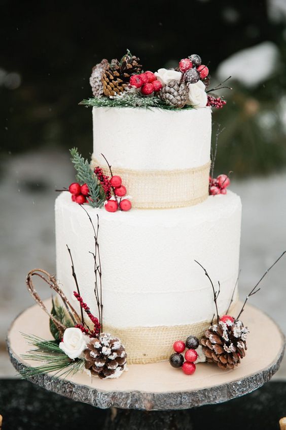 cake decorated with burlap, pinecones, berries and branches