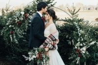 Christmas trees plus a gorgeous round wedding arch with greenery, white and burgundy blooms are amazing as a backdrop for a Christmas wedding