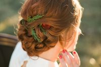 a beautiful and eye-catching copper braided and woven updo with greenery and a red rose is a stylish idea for a Christmas wedding