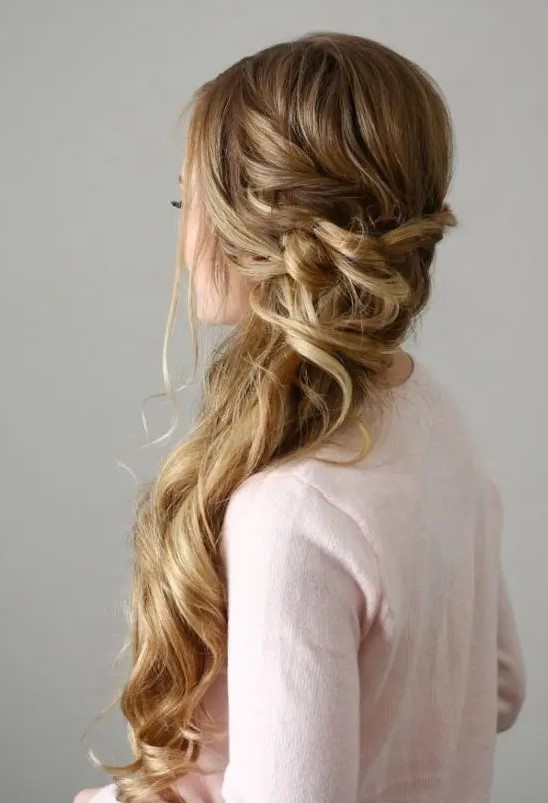 a beautiful side-swept Dutch braid with a twisted and wrapped touch and waves down plus face-framing hair