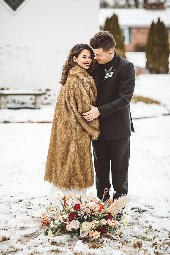 a beige midi faux fur coat with long sleeves is a stylish soluton for a bride, it looks cool and will keep her warm