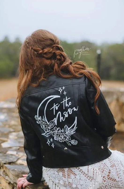 a boho bridal look finished off with a black leather jacket with white calligraphy and images is a great idea for a wedding