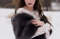 a bold boho winter bridal look with a lace fitting wedding dress with a high neckline and long sleeves, a grey faux fur cove rup and a gold hairpiece