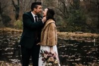 a brown faux fur short coat over a white wedding dress for a slight touch of color and a cozy feel outside
