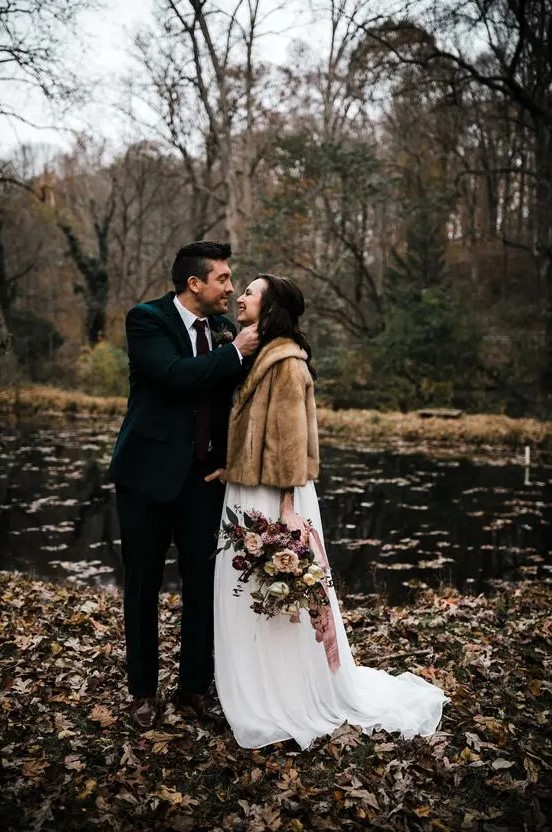 a brown faux fur short coat over a white wedding dress for a slight touch of color and a cozy feel outside