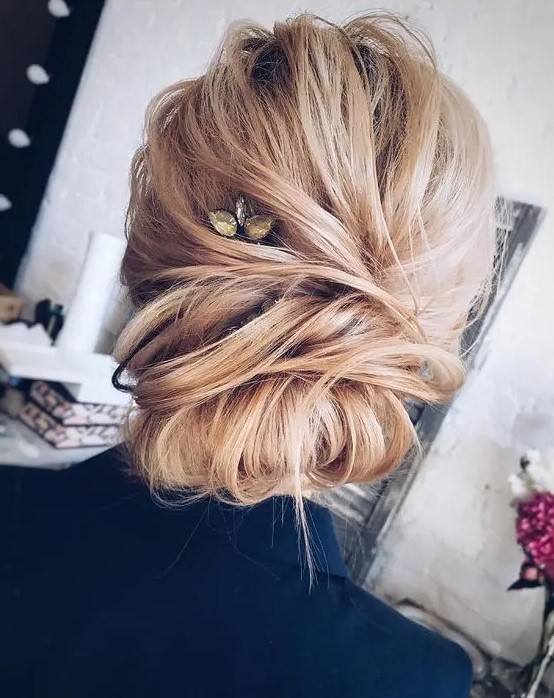 a casual twisted updo with a double chignon and a rhinestone hairpiece for an accent