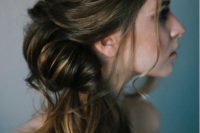 a catchy wrapped and twisted side ponytail with a bump on top and some waves is a chic and refined idea to try