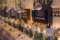 a charming winter wonderland wedding reception space with evergreens, crystals, lights, candles, pinecones and white linens