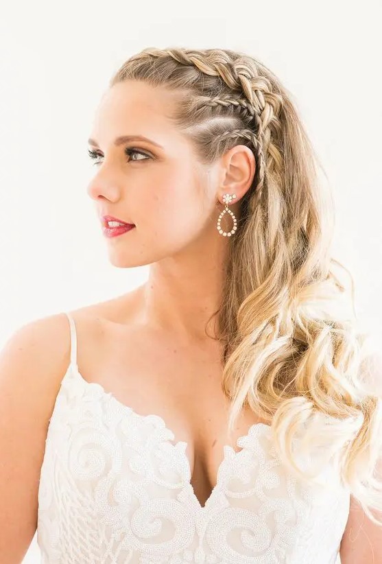 a chic side swept hairstyle with several braids on the sides, waves and curls is a lovely solution for a boho bride