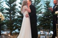 a classic winter wedding backdrop with evergreen trees, floating candles and greenery is a cool idea for a winter or Christmas wedding