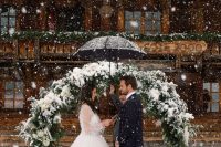 a classy round greenery wedding arch with white blooms and evergreens is a cool idea for a winter wedding