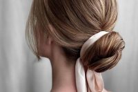 a classy wrapped low bun with a bump on top, a silk ribbon and face-framing locks is a chic and stylish idea