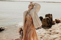 a gold sequin A-line wedding dress, black boots, a neutral faux fur coat for a statement and edgy bridal look
