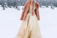 a gorgeous gold lace wedding dress and a pink faux fur jacket fo a dreamy and fairy-tale like bridal look