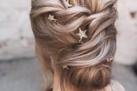 a loose updo with a bump on top and some star hair pins plus hair down is a cool and chic idea for a celestial bride