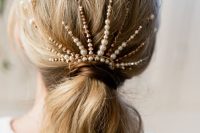 a low wavy ponytail with a bold rhinestone and pearl hair piece is a stylish idea to rock