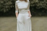 a modern elegant look with a silk crop top with a high neckline and short sleeves and palazzo pants plus strands of pearls